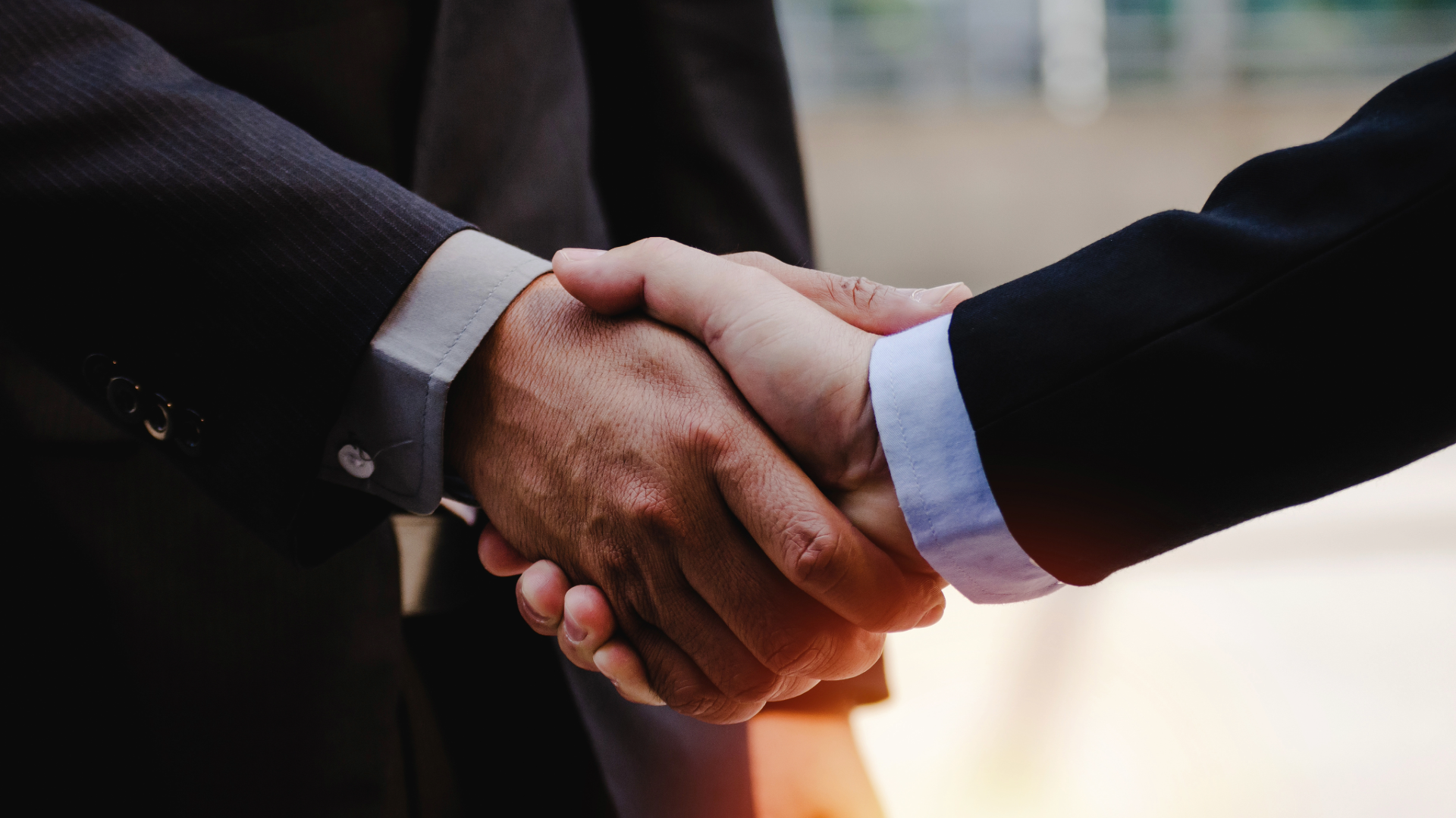 Two people shaking hands over a business deal.